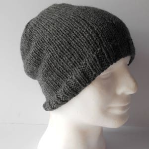 May include: A gray knitted beanie hat with a ribbed texture.