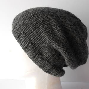 May include: A gray knitted beanie with a slouchy fit. The beanie is made of a soft, textured yarn.