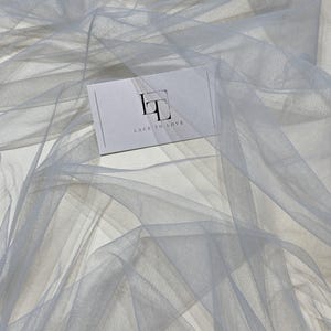 May include: A light gray tulle fabric with a white card that says "Lace to Love" on it.