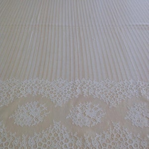 May include: White lace trim with a floral pattern. The lace has a scalloped edge and is perfect for adding a touch of elegance to any project.