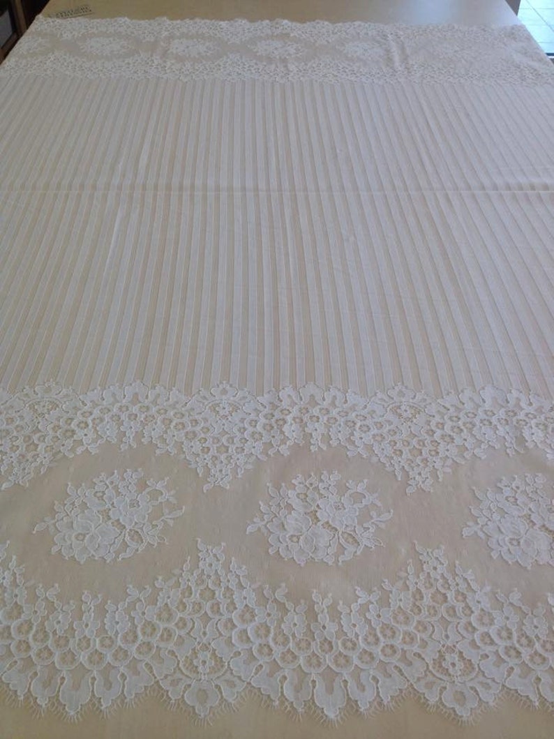 May include: White lace trim with a floral pattern. The lace has a scalloped edge and is perfect for adding a touch of elegance to any project.