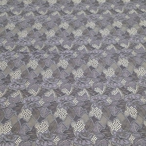 Puede incluir: Tela de encaje gris con un patr&oacute;n floral. El encaje tiene un dise&ntilde;o delicado e intrincado con peque&ntilde;os puntos blancos en todo.