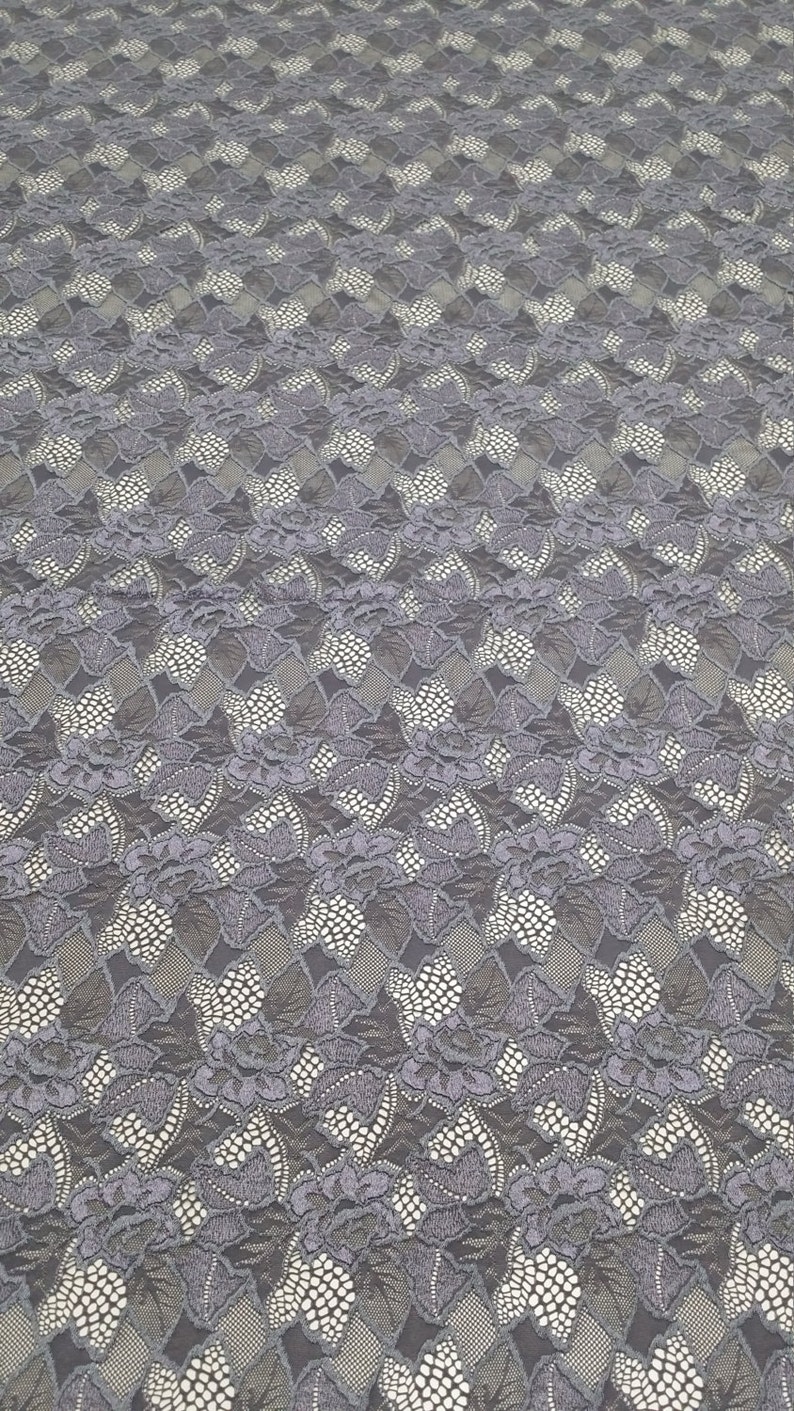 Puede incluir: Tela de encaje gris con un patr&oacute;n floral. El encaje tiene un dise&ntilde;o delicado e intrincado con peque&ntilde;os puntos blancos en todo.
