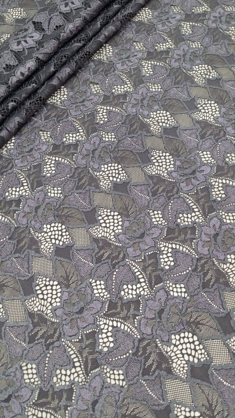 Puede incluir: Tela de encaje floral gris con un patr&oacute;n delicado. El encaje tiene un brillo sutil y es perfecto para proyectos de artesan&iacute;a o costura.