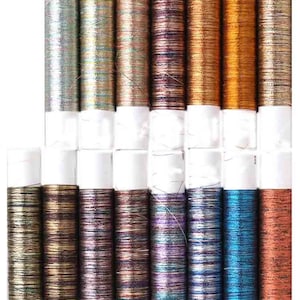 May include: Assortment of 20 spools of metallic embroidery thread in various colours, including gold, silver, blue, purple, and brown. The thread is wound around white spools.