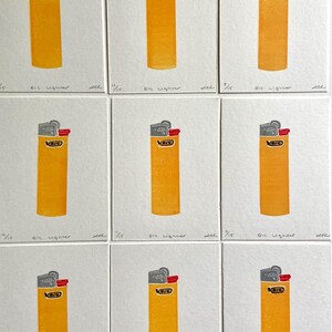 Op de afbeelding: Negen afdrukken van een gele BIC-aansteker met een grijze bovenkant en rode ontstekingsknop. Elke afdruk staat op een witte vierkant, met de tekst "BIC lighter" eronder. De afdrukken zijn gerangschikt in een raster.