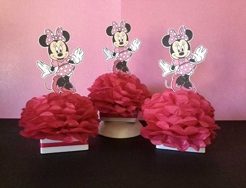 May include: Three pink and white Minnie Mouse centerpieces with red tissue paper pom-poms.