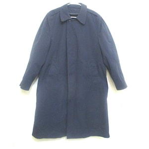 May include: A long-sleeved navy blue coat with a button closure and a collar.