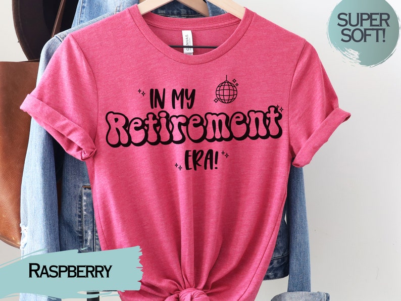 Op de afbeelding: Een roze T-shirt met de tekst "In My Retirement Era!" in zwart, met een discobal-afbeelding boven de tekst. Het shirt is gemaakt van een zacht, comfortabel materiaal.