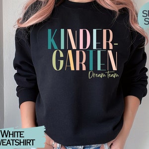 May include: Black sweatshirt with the text "KINDERGARTEN Dream Team" in colorful letters. The sweatshirt is made of soft material.
