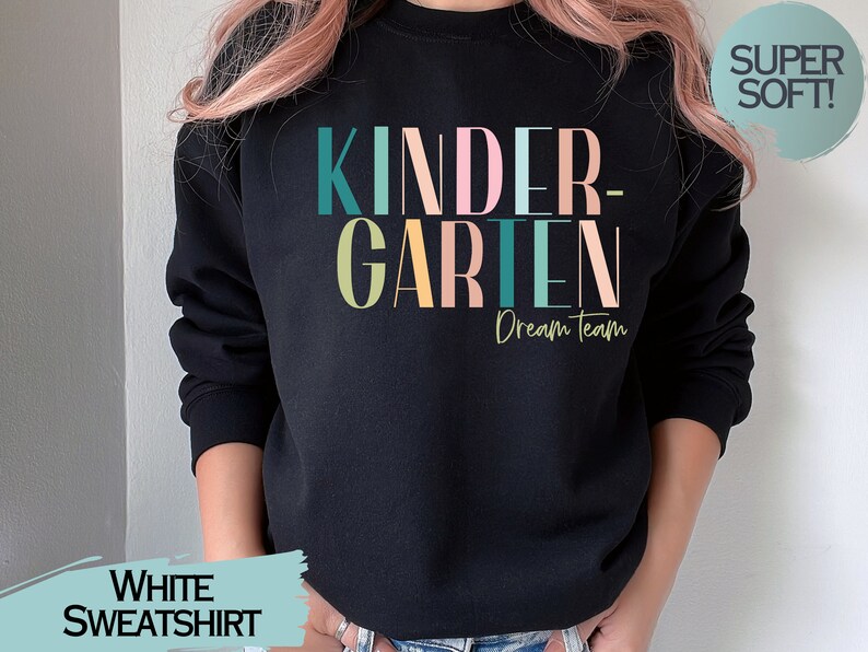 May include: Black sweatshirt with the text "KINDERGARTEN Dream Team" in colorful letters. The sweatshirt is made of soft material.