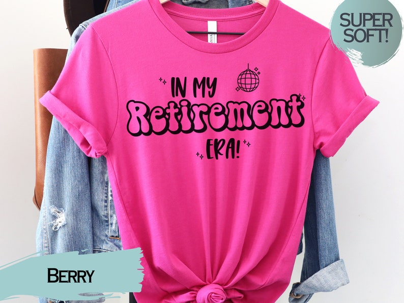 Op de afbeelding: Roze T-shirt met zwarte tekst die "In My Retirement Era!" luidt, met een discobal-afbeelding.