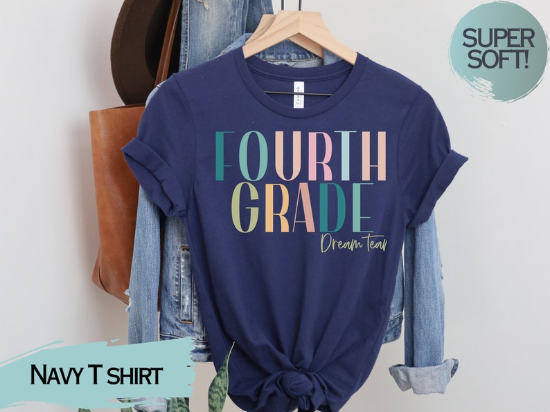 May include: Navy blue t-shirt with the text "FOURTH GRADE Dream Team" in colorful letters. The shirt is made of a soft, comfortable material.