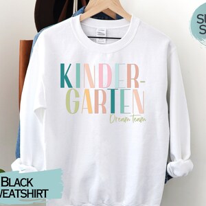 May include: White sweatshirt with the text "KINDERGARTEN Dream Team" in colorful letters. The sweatshirt is super soft.