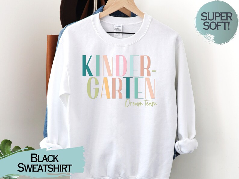May include: White sweatshirt with the text "KINDERGARTEN Dream Team" in colorful letters. The sweatshirt is super soft.