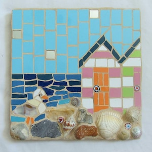 May include: A square mosaic art piece depicting a beach scene. The sky is light blue, the sea is dark blue, and a duck is in the water. A colorful beach hut is on the right, with seashells and stones at the bottom. The mosaic is made of small, square tiles.
