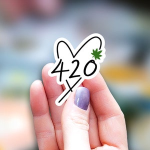 May include: A white sticker with a black heart design and the number 420 inside. A small green marijuana leaf is at the top of the heart.