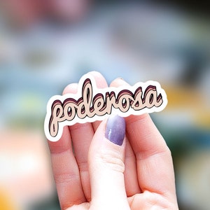 May include: A sticker with the word "poderosa" written in a retro style font with pink, brown, and white colors.