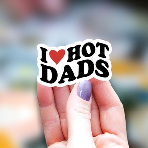 May include: White sticker with black text that reads "I ♥ HOT DADS". A red heart is in place of the word "love".