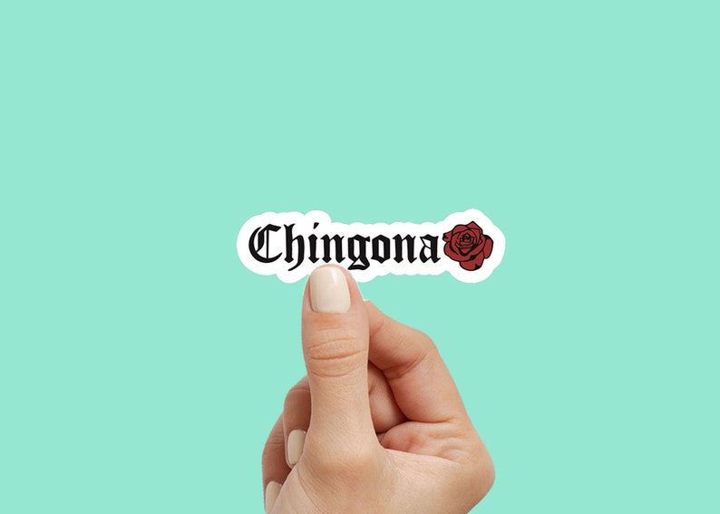 Pu&ograve; includere: Un adesivo con la parola "Chingona" in font gotico e una grafica di rosa rossa.