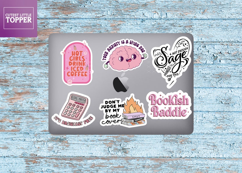 May include: A set of six pink and black laptop stickers with various designs and text. The stickers include a brain with the text "Your anxiety is a bring hoe", a calculator with the text "Girl Math, It's basically free", a stack of books with flames and the text "Don't judge me by my book covers", a heart with the text "Sage, Not enough for this", a cup of iced coffee with the text "Hot girls drink iced coffee", and a stack of books with the text "Bookish Baddie".