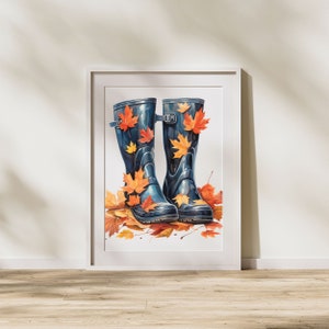 May include: A pair of blue rain boots with orange and yellow leaves on them. The boots are sitting on a white background.