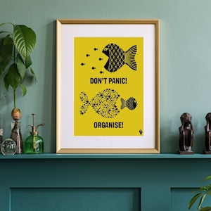 Puede incluir: Un póster enmarcado con fondo amarillo e ilustraciones de peces negros. El póster dice "¡No te asustes! ¡Organízate!"
