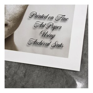 Pu&ograve; includere: Primo piano di un passepartout bianco con il testo "Printed on Fine Art Paper Using Archival Inks" in corsivo nero.