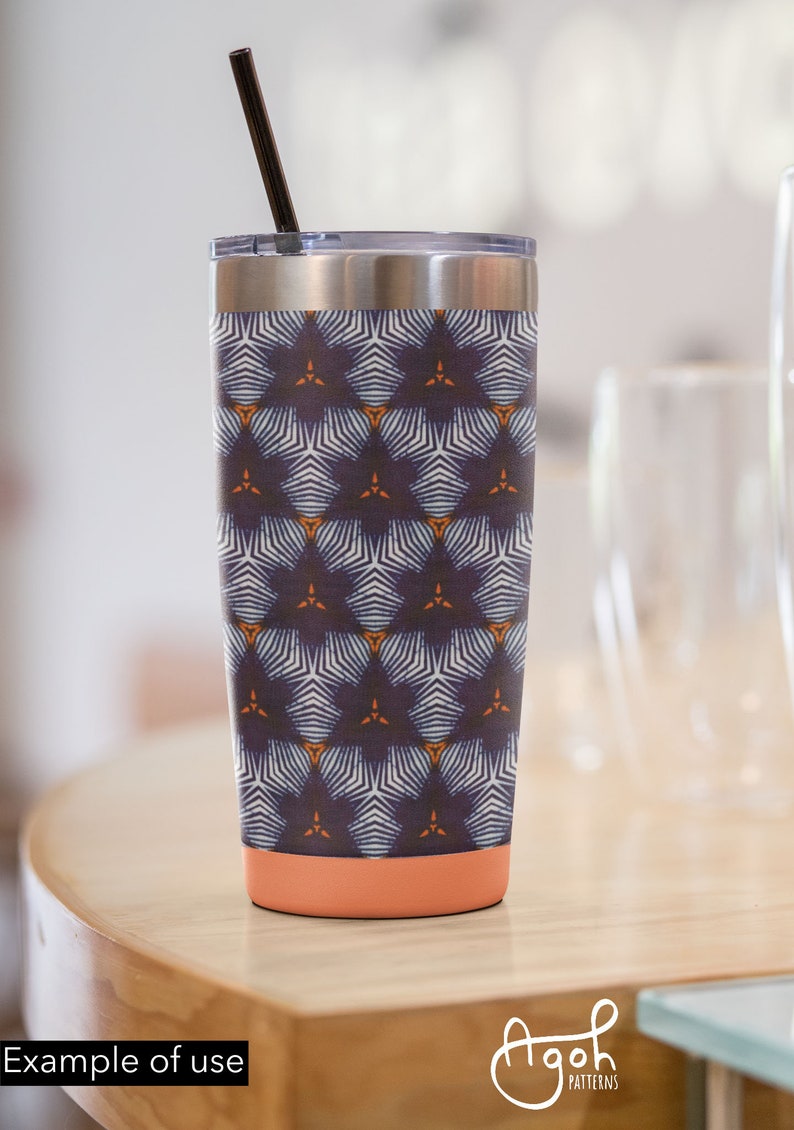 May include: A stainless steel tumbler with a navy blue, white, and orange geometric pattern. The tumbler has a coral-colored bottom and a black straw.