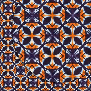 May include: A seamless pattern of orange, white, and blue geometric shapes on a dark blue background. The pattern is made up of repeating crosses and circles.