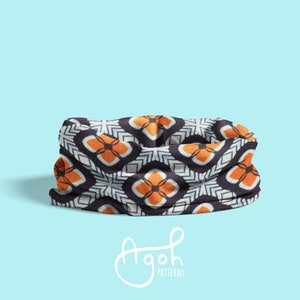 May include: A black, white, and orange patterned neck gaiter. The pattern features geometric shapes and a repeating design.