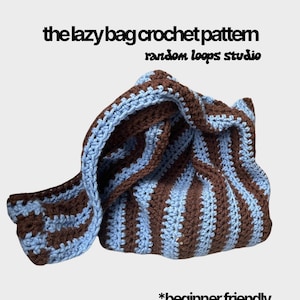 May include: A crocheted bag in a striped pattern of brown and light blue. The text "the lazy bag crochet pattern random loops studio" is at the top, with "*beginner friendly" at the bottom.