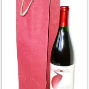 Peut inclure: Un sac à vin en papier rouge avec une poignée en jute. Le sac est conçu pour contenir une bouteille de vin de taille standard.