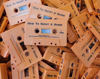 Puede incluir: Un montón de cintas de casete de plástico naranja, cada una etiquetada con How To Haunt A House en texto negro. Las cintas presentan el texto Made and Printed in U.S.A. y 1995 Abracadazzle, An Imprint of Random House, Inc./MagicCoin, Inc. impreso en el frente.