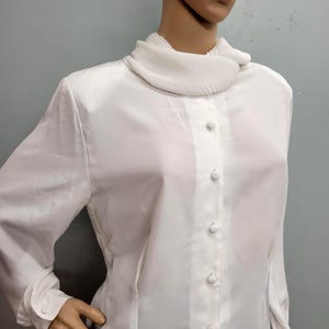 Camisa de vestir vintage de los años 80 con cuello de volantes y blusa blanca con cuello enrollado y pliegues.