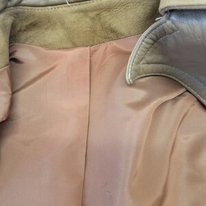 May include: The inside of a brown leather jacket with a brown satin lining.