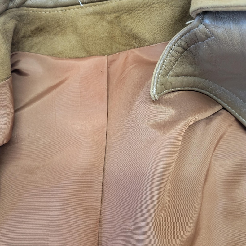 May include: The inside of a brown leather jacket with a brown satin lining.