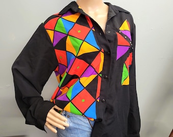 Blusa vintage de los 80 con bloques de color sedosos, camisa fluida con tachuelas y estilo funky.
