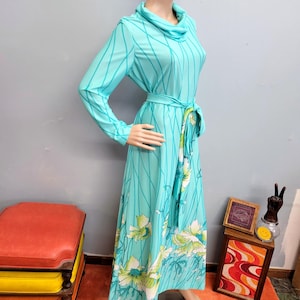 May include: A white ceramic mug with a black handle and the text "But First, Coffee" in a black, handwritten-style font. The mug is on a white surface.