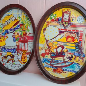 May include: Two oval-shaped serving trays with dark brown faux wood grain rims. The left tray features a person in a yellow hat watering plants with a cat nearby. The right tray shows a person in a yellow hat sitting in a rocking chair by a fireplace.