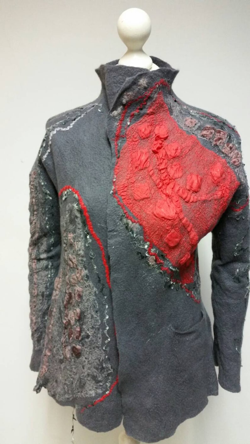 May include: A gray wool jacket with a red, pink, and gray patterned design. The jacket has a collar and long sleeves.