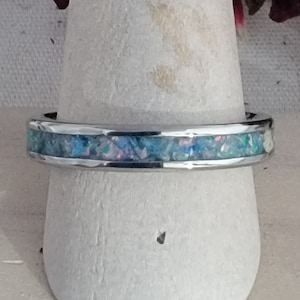May include: A silver ring with a blue and white opal inlay.