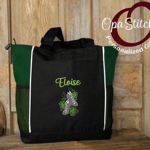 May include: A black and green tote bag with a white trim. The bag has a personalized embroidery of the name "Eloise" and a pair of green shamrock-decorated shoes.