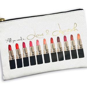 Pu&ograve; includere: Borsa bianca con cerniera e tiretto dorato. La borsa ha uno sfondo bianco con lettere dorate che dicono "Love & Lipstick" e "All you need is..." La borsa presenta una fila di 14 tubetti di rossetto in varie tonalit&agrave; di rosso, rosa e arancione.