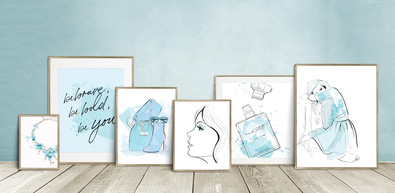 May include: Set of six framed prints with a blue and white watercolor theme. The prints feature a necklace, a quote about being brave and bold, a pair of shoes and a handbag, a woman's face, a bottle of perfume, and a woman in a dress.