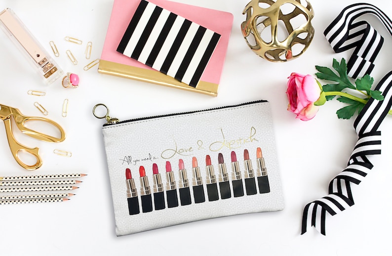 Pu&ograve; includere: Una pochette bianca con cerniera e un'iscrizione dorata che recita "Tutto ci&ograve; di cui hai bisogno &egrave; amore e rossetto". La pochette presenta una fila di 14 tubetti di rossetto con diverse tonalit&agrave; di rosso, rosa e nude.