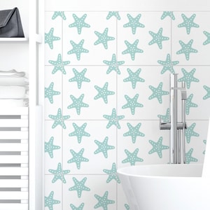May include: White bathroom with a white bathtub and a white shelf unit. The wall behind the bathtub has a tiled pattern of light blue starfish.