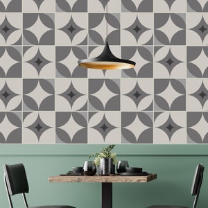 May include: A dining room with a green wall and a black pendant light hanging over a wooden table with two black chairs. The wall is covered in a geometric pattern of gray and white tiles.