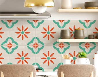 May include: A kitchen backsplash with a repeating pattern of teal blue and orange floral designs. The backsplash is installed behind a white countertop and a stainless steel range hood.
