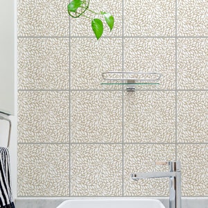 May include: White bathroom tiles with a brown leaf pattern. A glass shelf is mounted on the wall above a white porcelain sink with a chrome faucet.
